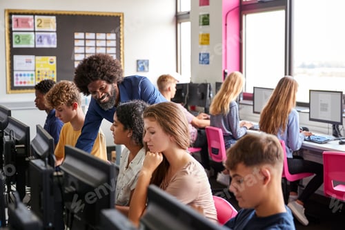 Preview: Male Teacher Helping Teenage Female High School Student Working In Computer Class