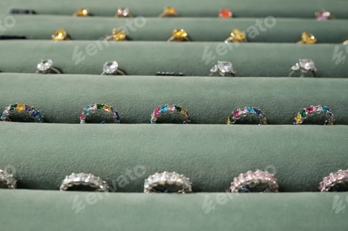 Preview: Part of display with rows of rings between grey velvet holders