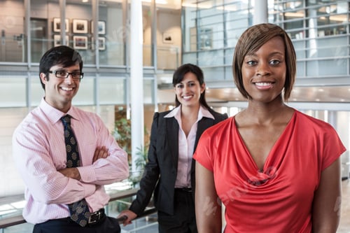 Preview: Mixed race team of business people in the lobby of a large office building.