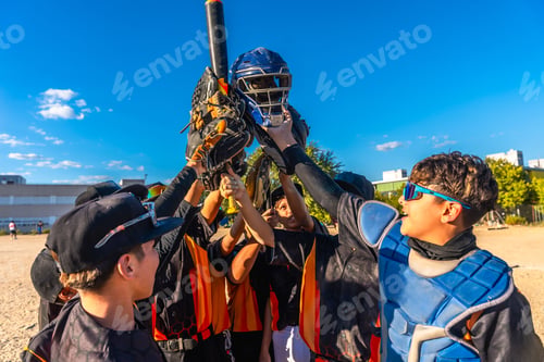 Preview: Youth baseball team celebrating victory holding equipment up