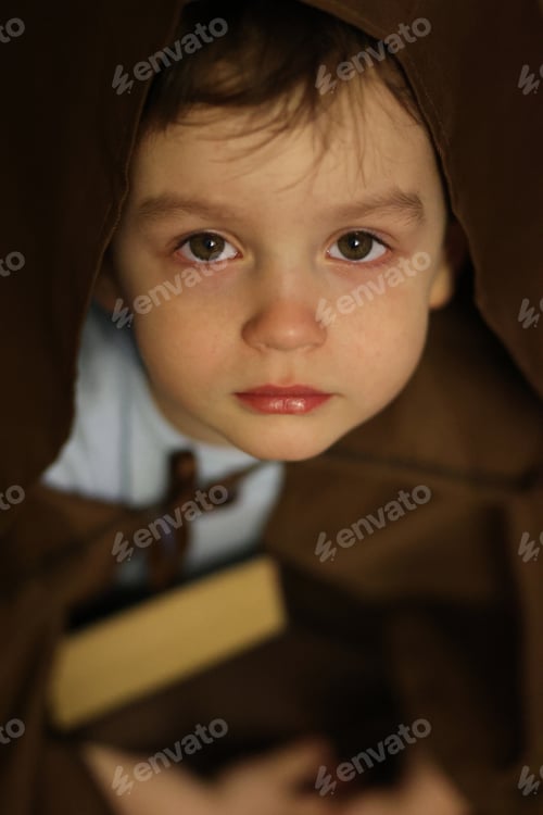 Preview: A boy in a cape holds a book in his hands.