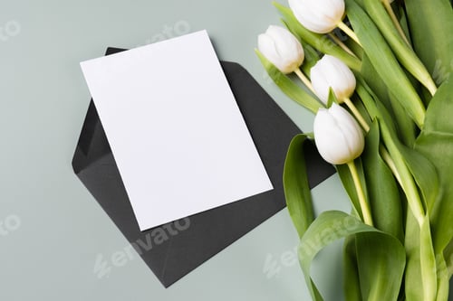 Preview: Blank card in envelope and bouquet of tulips. Mockup paper blank invitation or greeting card.