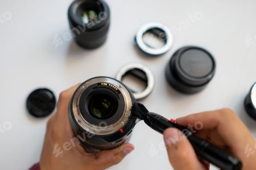 Preview: top view of a master repair modern camera equipment, cleaning dust on the lens