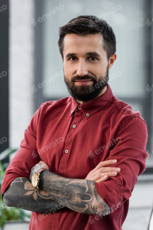 Preview: handsome and smiling account manager with crossed arms looking at camera