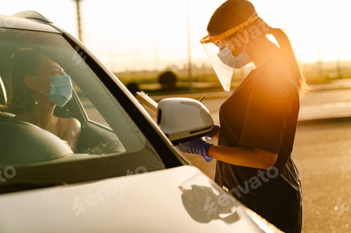 Preview: Black health worker writing down notes while talking car drive