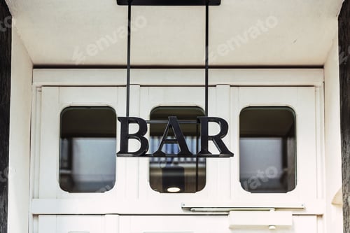 Preview: Sign with the text BAR on the door of a pub for drinks.