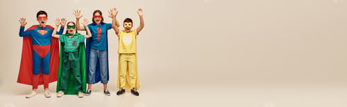 Preview: courageous interracial kids in colorful costumes with cloaks and masks screaming and raising hands