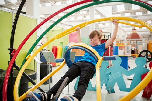 Preview: Young white boy in science centre using human gyroscope