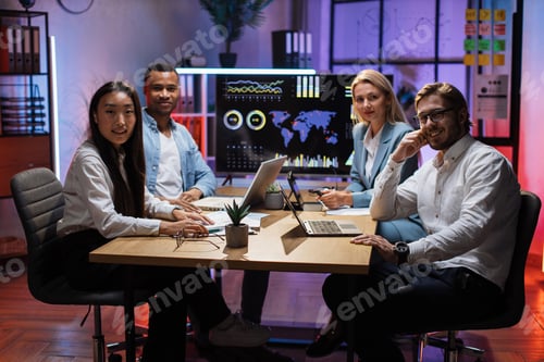 Vista previa: Diversos economistas sentados en el escritorio con aparatos modernos