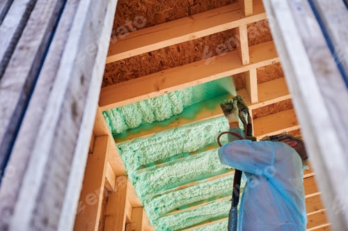 Preview: Worker spraying polyurethane foam for insulating wooden frame house.