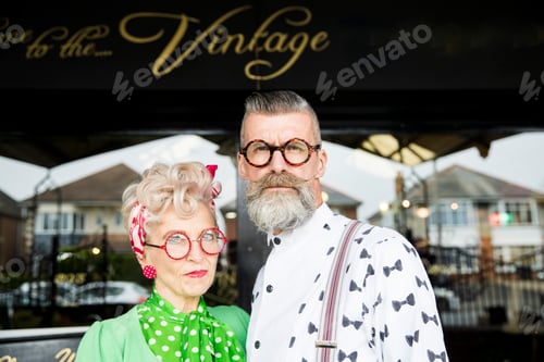 Preview: Serious portrait of a quirky vintage couple outside vintage shop