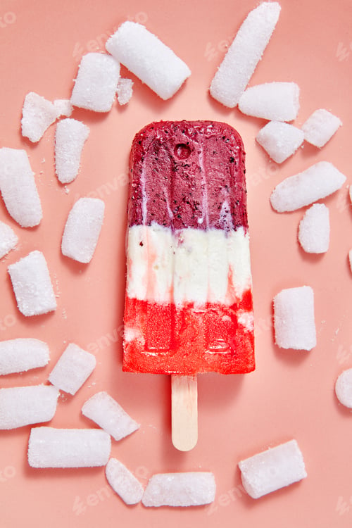 Preview: Multicolored berry ice cream on a stick with ice cubes on a color background of the year 2019 Living