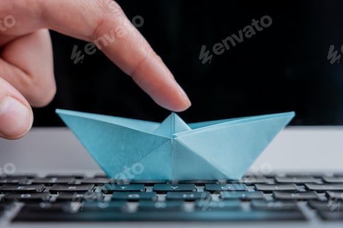 Aperçu: Plan à mise au point sélective d'un bateau en papier sur le clavier d'un ordinateur portable