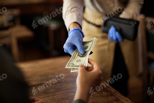 Preview: Close-up of customer paying to a waitress in a cafe.