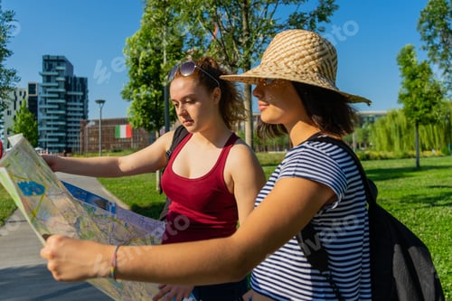 Preview: Caucasian young female tourists looking at the city map
