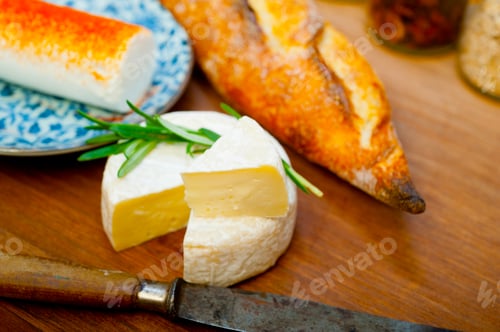 Preview: French cheese and fresh baguette on a wood cutter