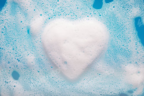Preview: Heart-shaped foam over blue water with copy space.