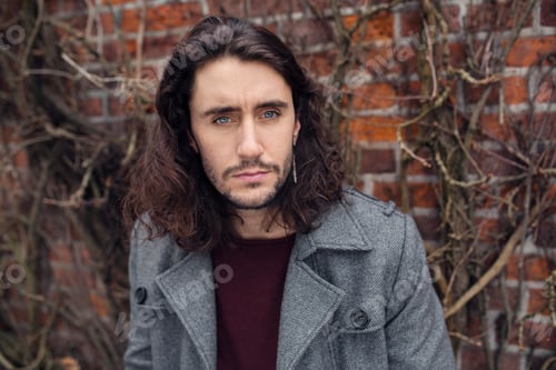 Preview: Portrait of young man with long hair outdoors