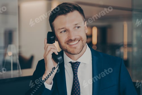 Preview: Satisfied male office worker calling his wife to notify her about promotion