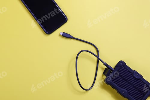 Preview: cheapest source of electricity. power box, portable solar battery for phone on yellow background.
