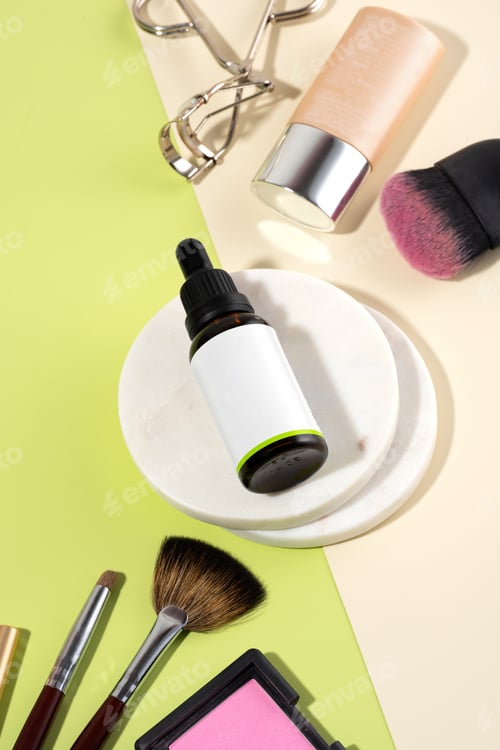Preview: Serum primer with dropper on beige-green background. A set of makeup accessories and bottle with fac