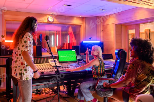 Preview: Singer singing a song while the producer is working on a soundboard in a studio
