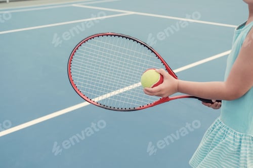 Preview: Young Asian girl tennis player on outdoor blue court