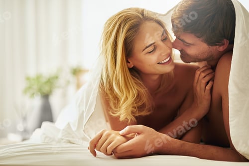 Preview: I want you and only you. Shot of a young couple sharing an intimate moment under the covers in bed.