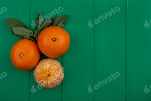 Preview: top view copy space oranges with peeled on green background