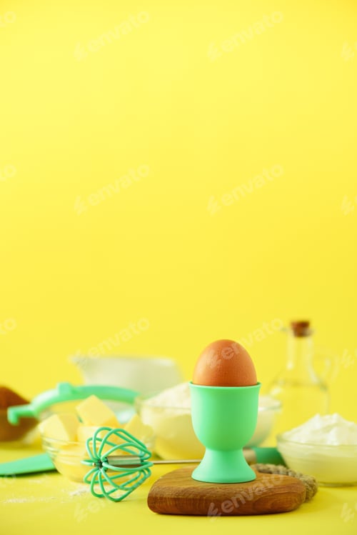 Preview: Healthy baking ingredients - butter, sugar, flour, eggs, oil, spoon, brush, whisk, milk over yellow