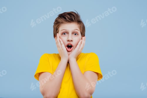 Preview: shocked preteen boy looks at camera in yellow t-shirt