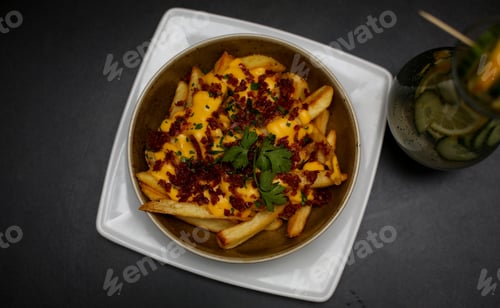 Preview: Top view of an appetizing french fries served with sauces and some greens