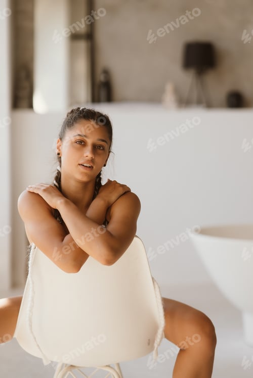 Preview: Girl in lingerie sits on a chair and looks at the camera