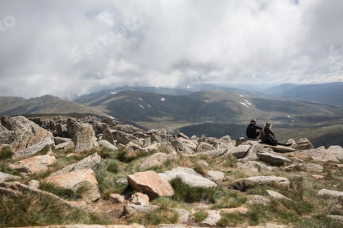 Hikers Enjoying the Mountain View on a Cloudy Day