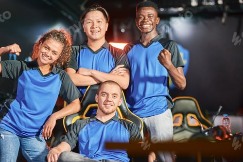 Preview: Celebrating success. Happy multiracial cybersport team smiling at camera and gesturing after eSport