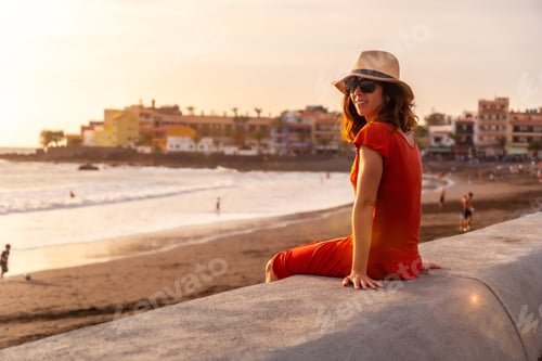 Preview: Tourist woman at sunset on vacation on the beach of Valle Gran Rey village on La Gomera, Canary