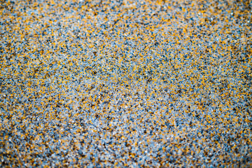 Preview: Feet wearing painters' wooden shoes with nails for self leveling epoxy on floor background. Close up
