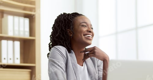 Preview: Delighted African American lady executive using her laptop in office
