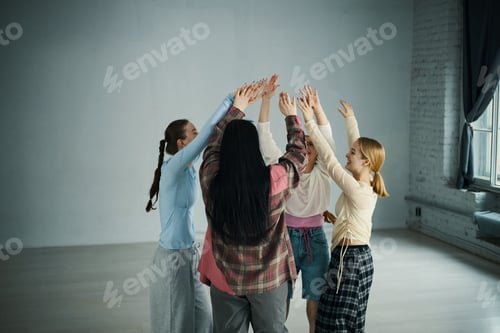 Preview: Group of Youth Celebrating and Uplifting in Bright Room