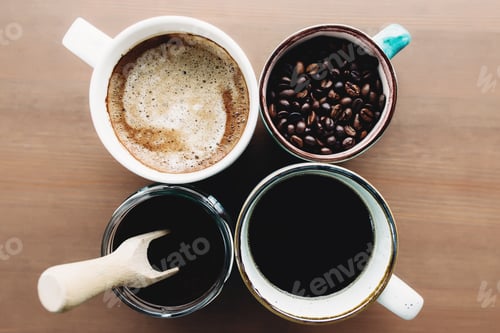 Preview: Multiple coffee cups, milk, beans and ground coffee in jar on wooden background