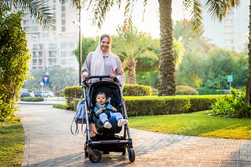 Preview: Woman Pushing Child in Stroller in a Park