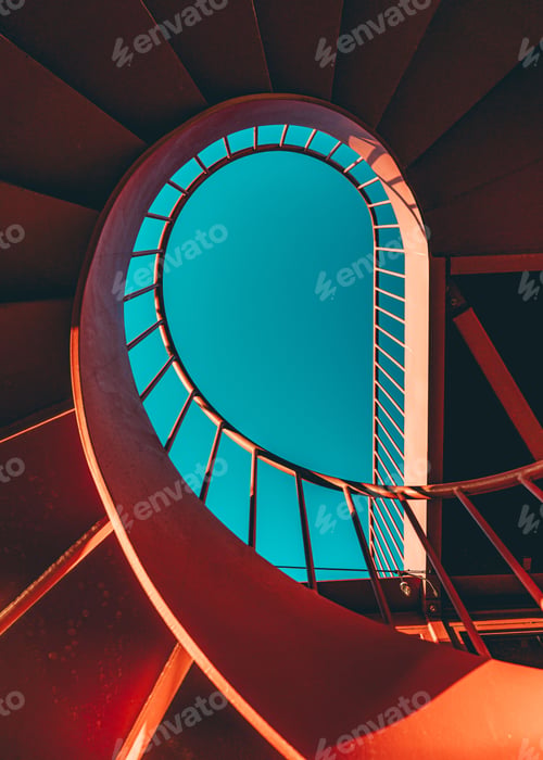 Preview: Vertical low angle shot of a spiral staircase against a blue sky