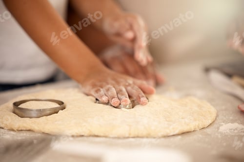 Preview: Cropped shot of an unrecognizable girl using a cookie cutter while making cookies at home