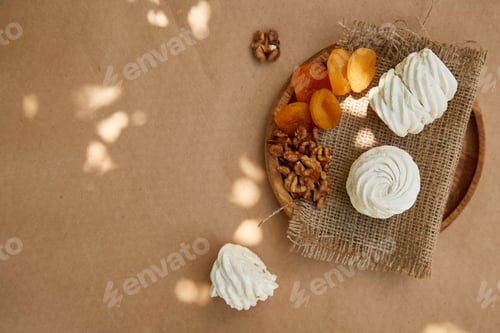Preview: Natural marshmallows with dried apricots, walnuts. Copy space. Cozy garden