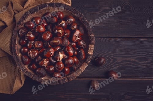 Preview: roasted chestnuts, in a wooden plate, top view, homemade, no people,