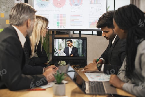 Preview: Group Of Businesspeople Having Video Conference In Boardroom in modern office