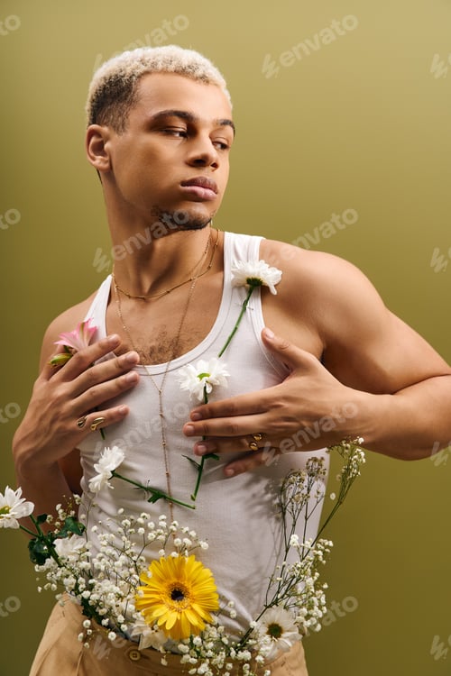 Preview: Young Black man displays vibrant style amid flowers in a studio setting