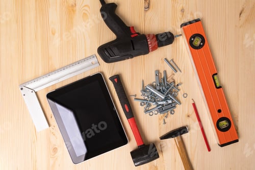 Preview: construction tool and a digital tablet lie on a light wooden table