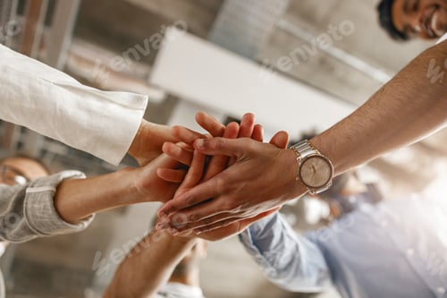 Preview: Bottom view of group multi ethnic coworkers stacked hands together as concept of corporate unity