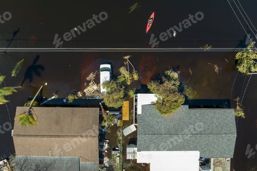 Preview: Kayak boat floating on flooded street surrounded by hurricane Ian rainfall flood waters